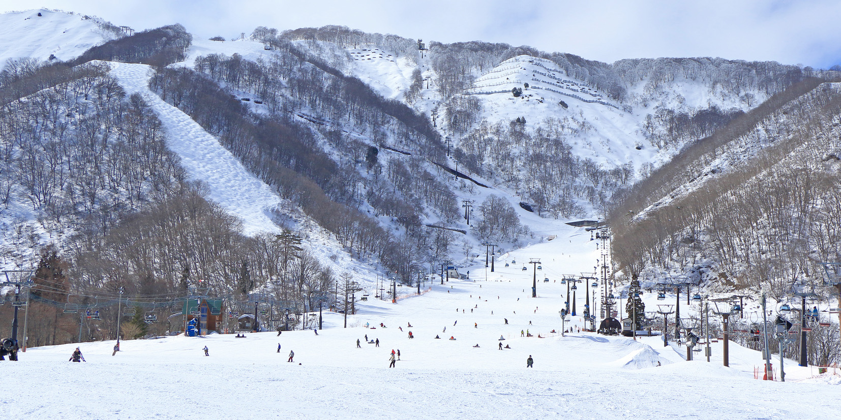 Hakuba 47 | Goryu in Japan - a group of people skiing down a snowy mountain.