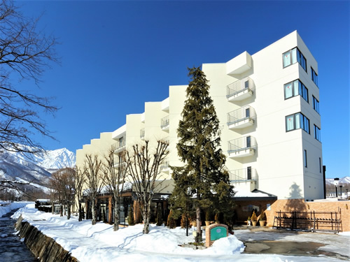 Image of Hakuba 47 | Goryu ski resort in Chūbu, Japan. A charming chalet sits by a bustling winter sports centre amidst a stunning winter scenery.