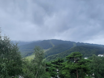 View of Deogyusan Resort in South Korea, featuring a breathtaking winter landscape with a mountain and challet nestled among snowy peaks, potentially a ski resort nearby.