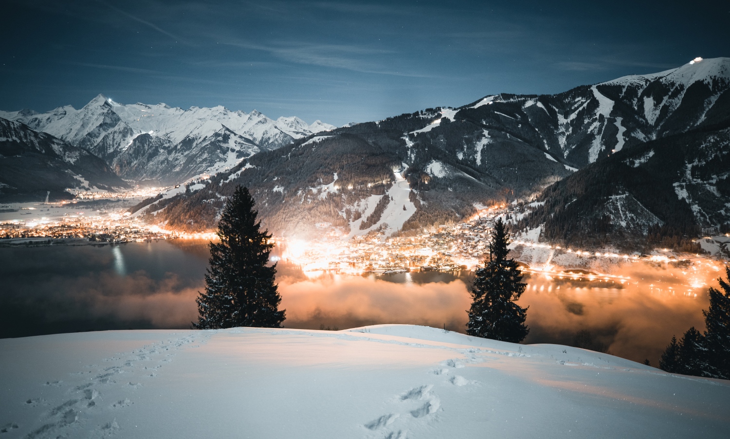 See in Austria - a view of a town and mountains at night.