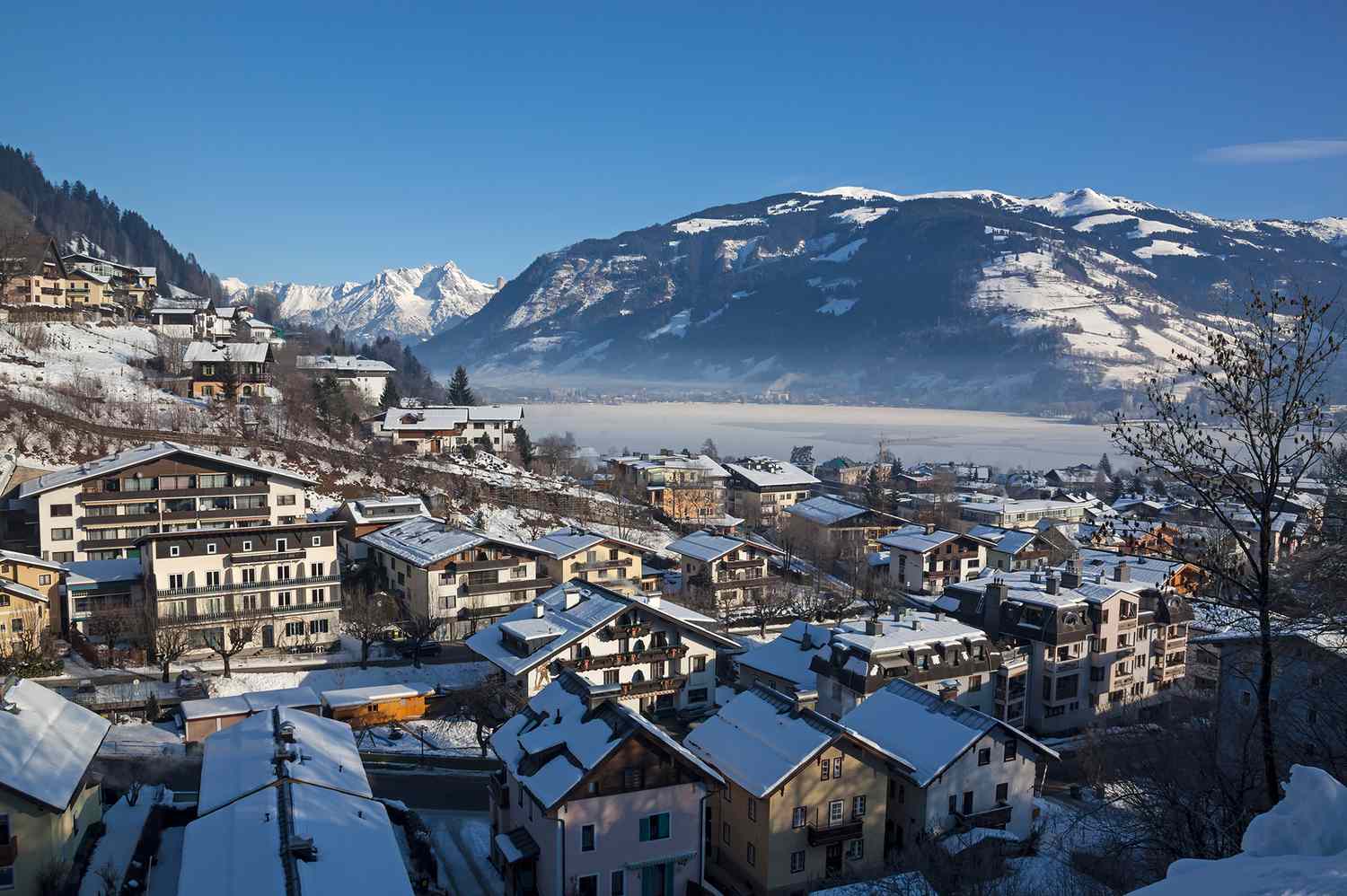 See in Austria - a view of a snowy town with mountains in the background.