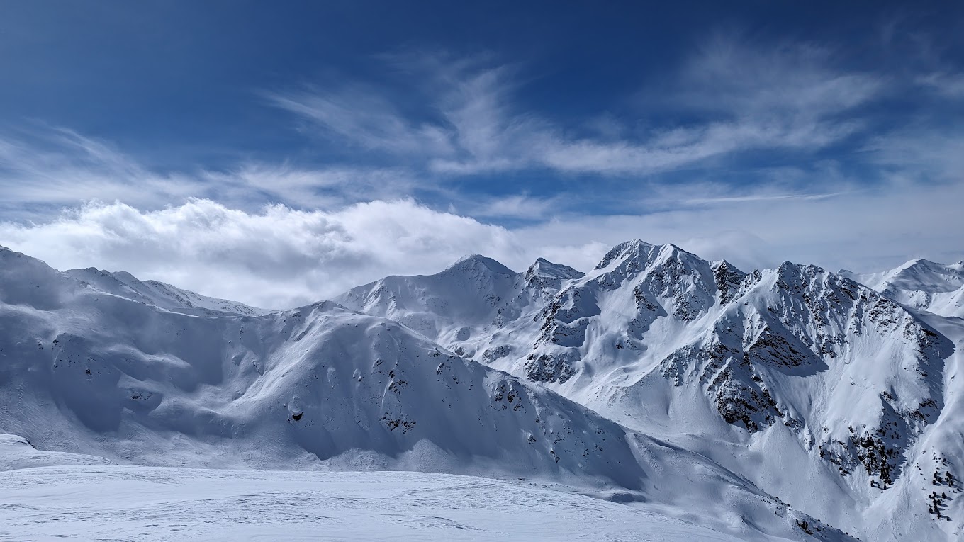 See in Austria - a snowy mountain with snow covered mountains in the background.