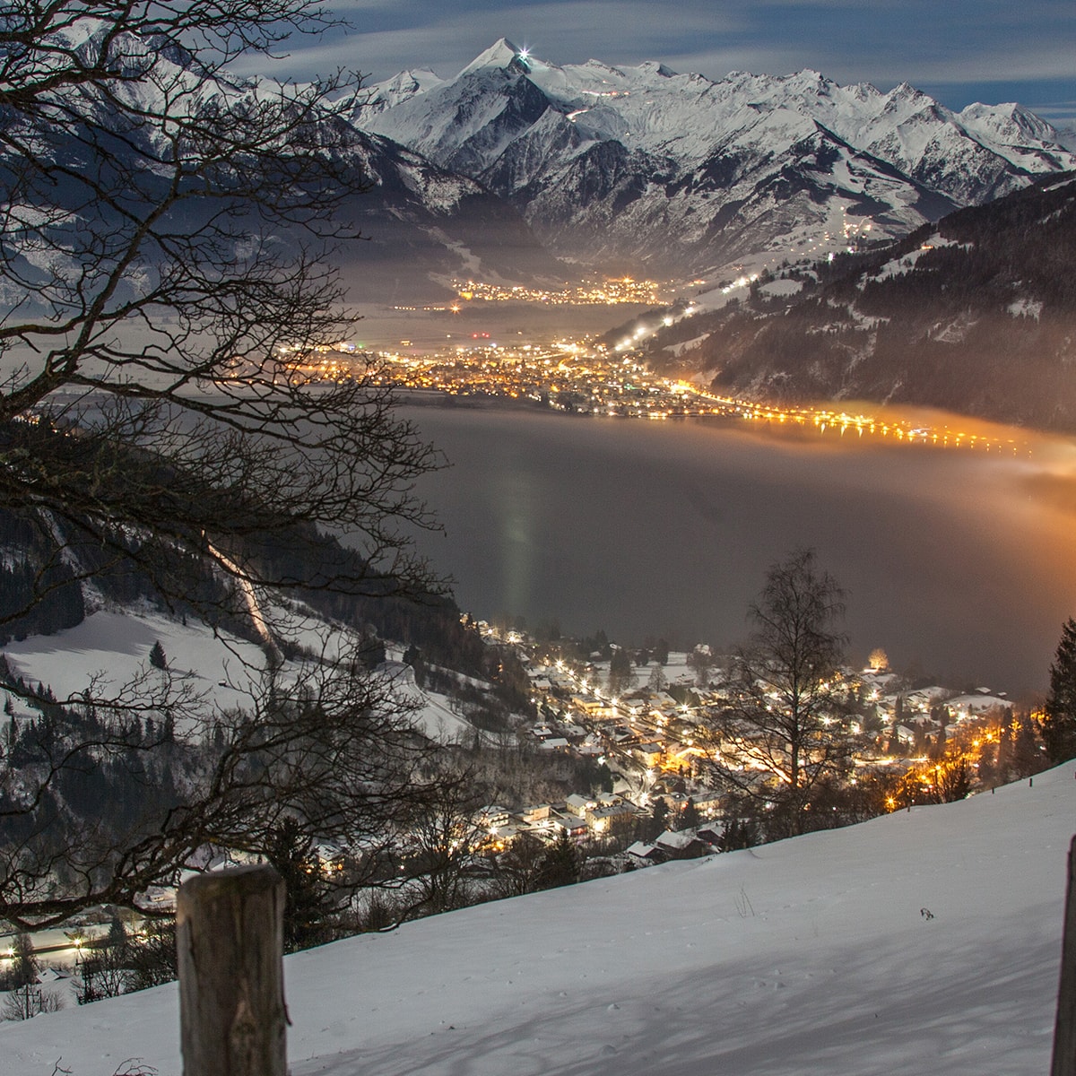 See in Austria - a view of a town and a lake at night.