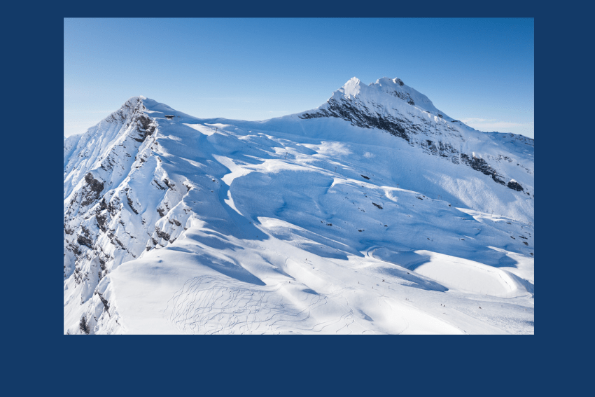 Avoriaz 1800 in France - a view of a snowy mountain with a blue sky.