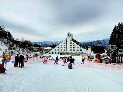 View of Campo Felice Ski Resort in Abruzzo, Italy, featuring a well-equipped winter sports centre amidst stunning snowy scenery, with a picturesque chalet nestled nearby.