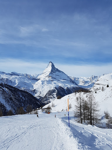 Wolli Park Sunnegga in Switzerland - a snow covered ski slope with mountains in the background.