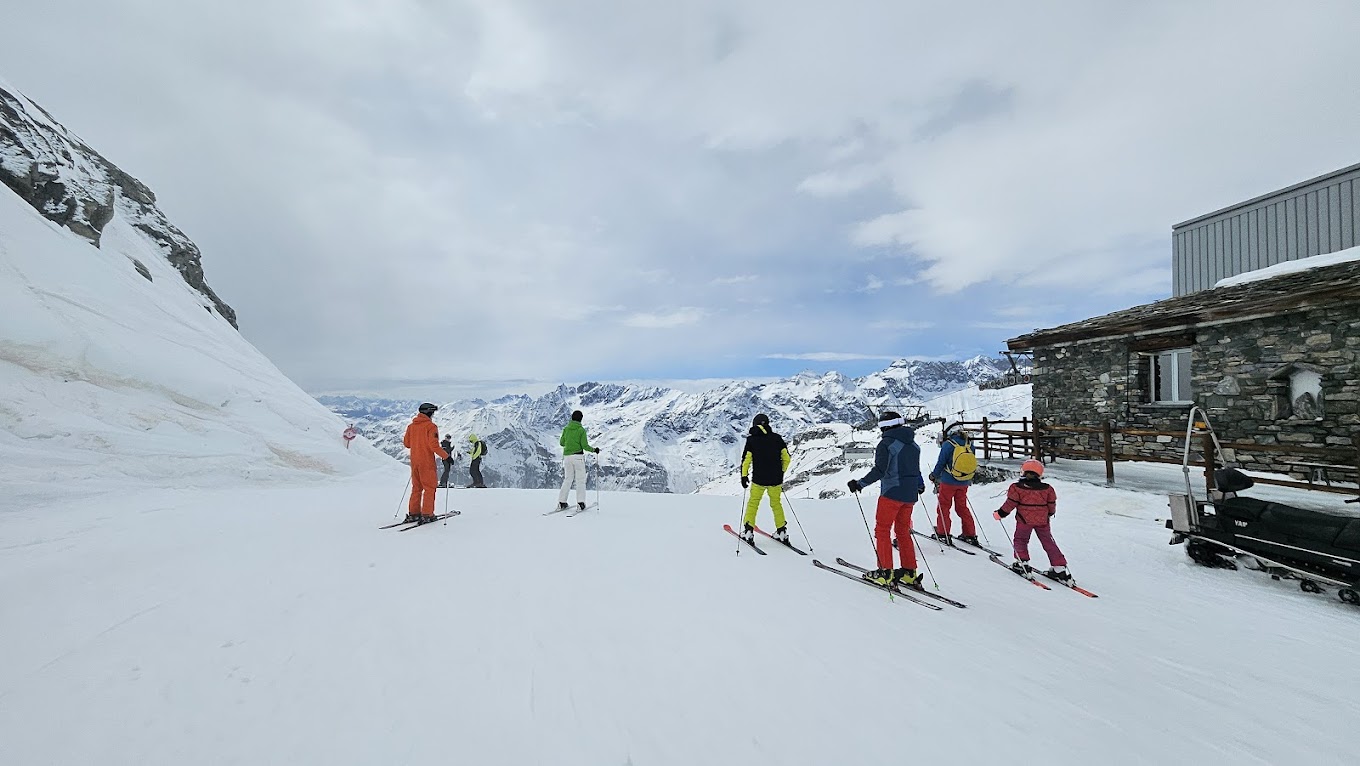 Cime Bianche Funivie Valtournenche in Italy - a group of people skiing down a snow covered mountain.