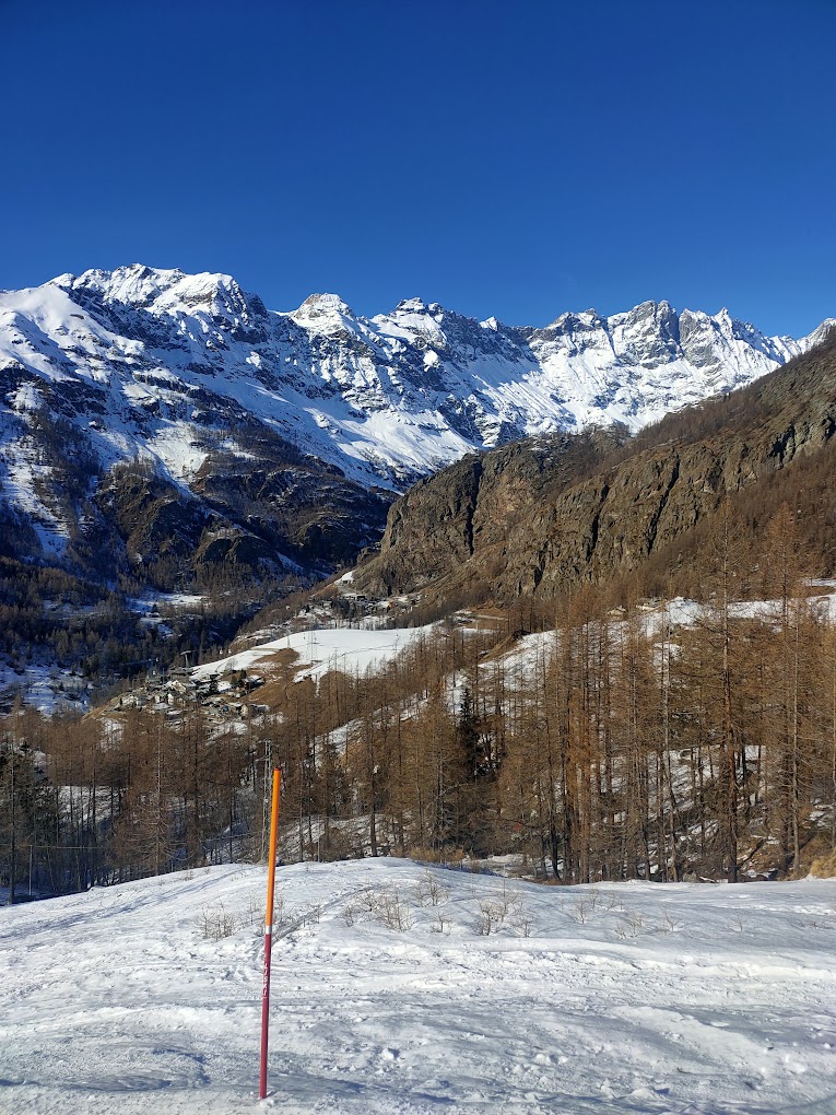 Cime Bianche Funivie Valtournenche in Italy - a ski slope with snow covered mountains in the background.