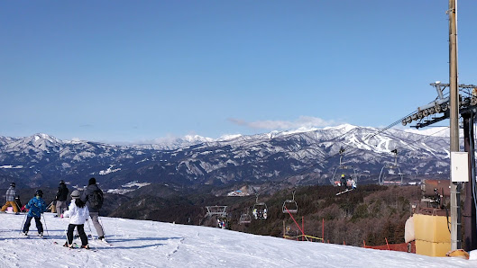 Skier enjoying winter sports at the Washigatake Ski resort in Japan surrounded by snow-covered slopes chalets and ski sports facilities.