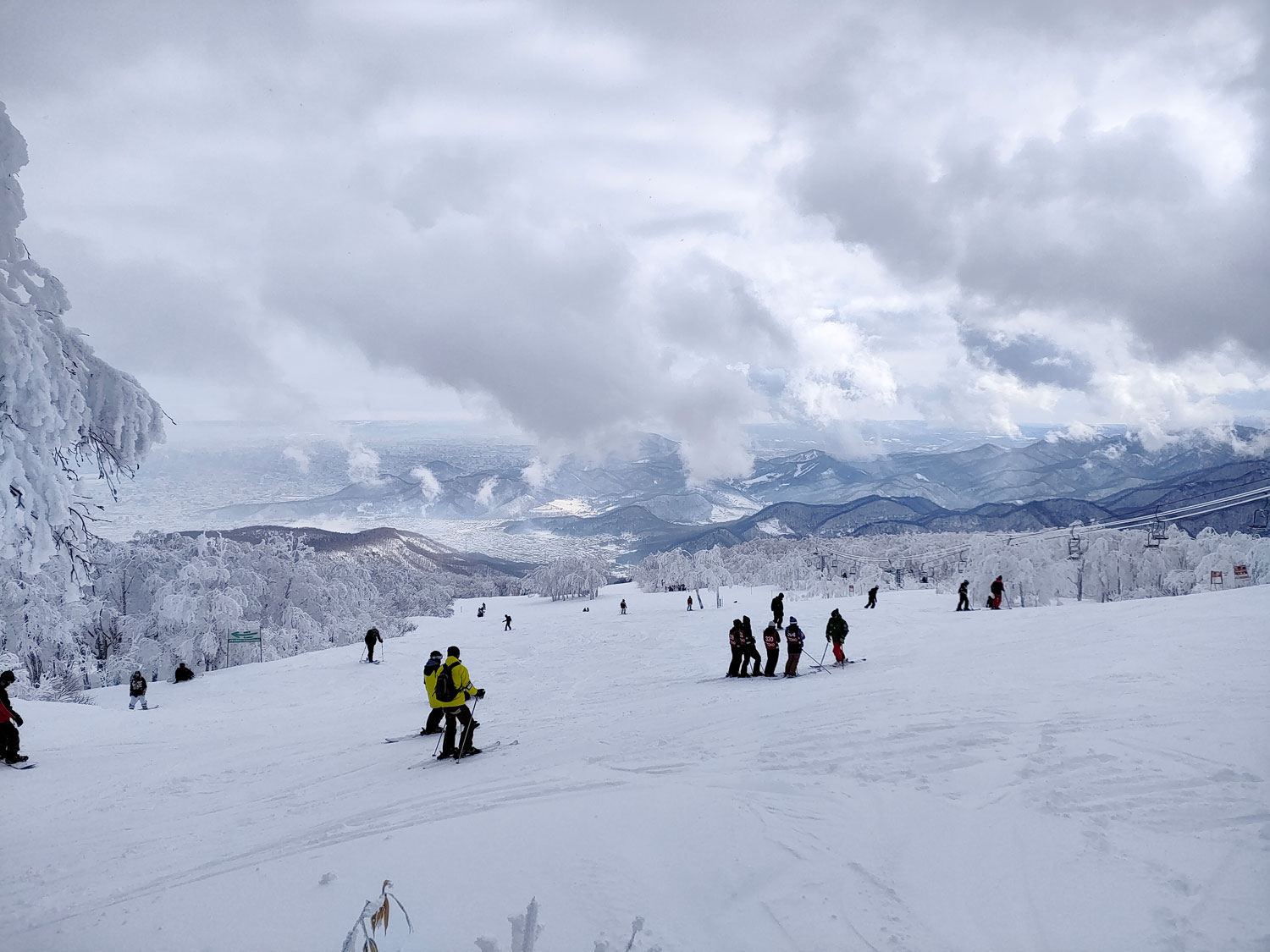 Sapporo Teine in Japan - a group of people skiing down a mountain.