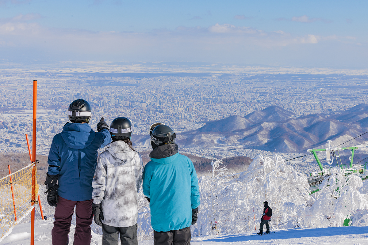 Sapporo Teine in Japan - a group of people standing on top of a snow covered mountain.