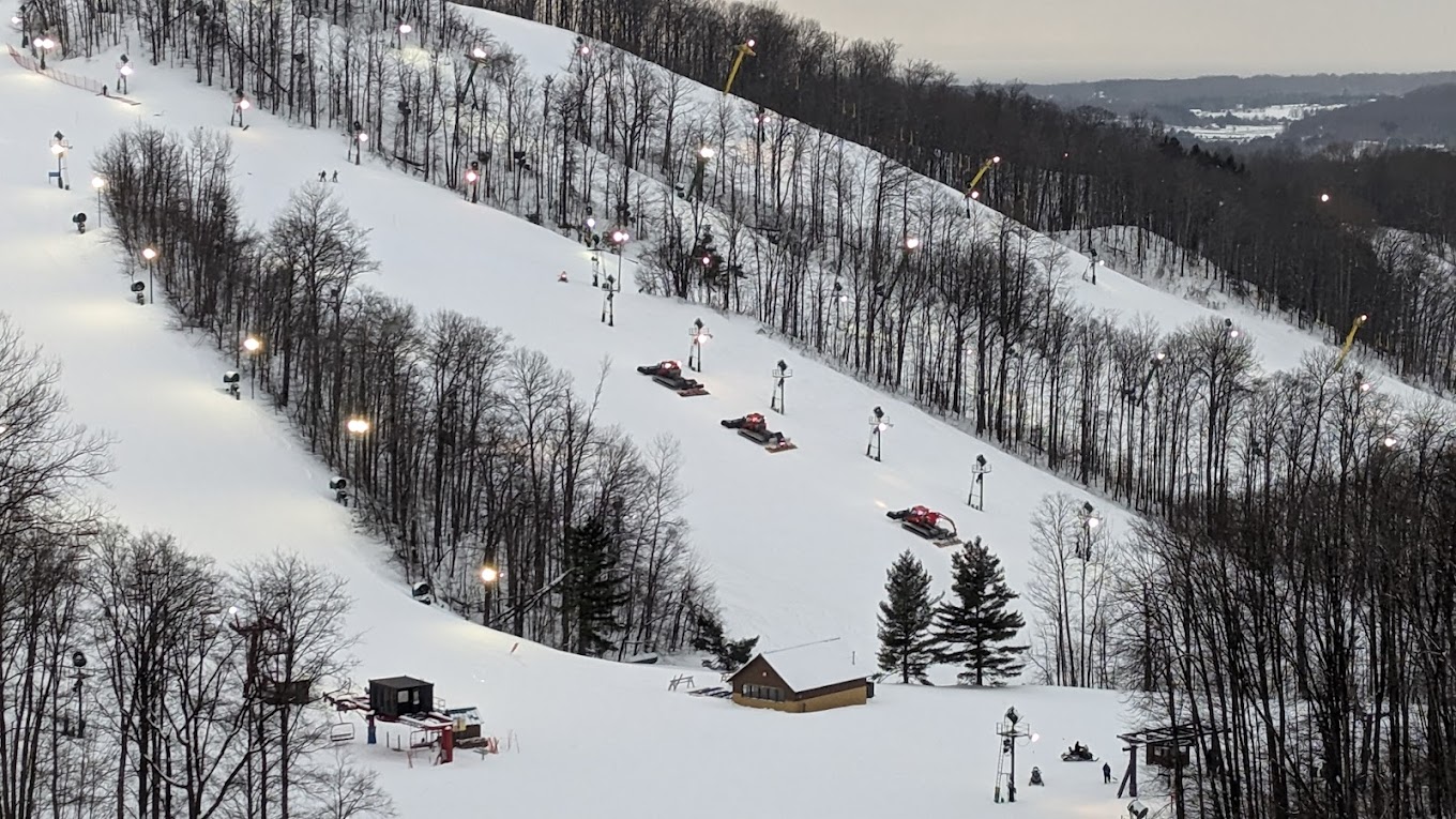 Nubs Nob Ski Area in USA - a ski slope with many people skiing down it.
