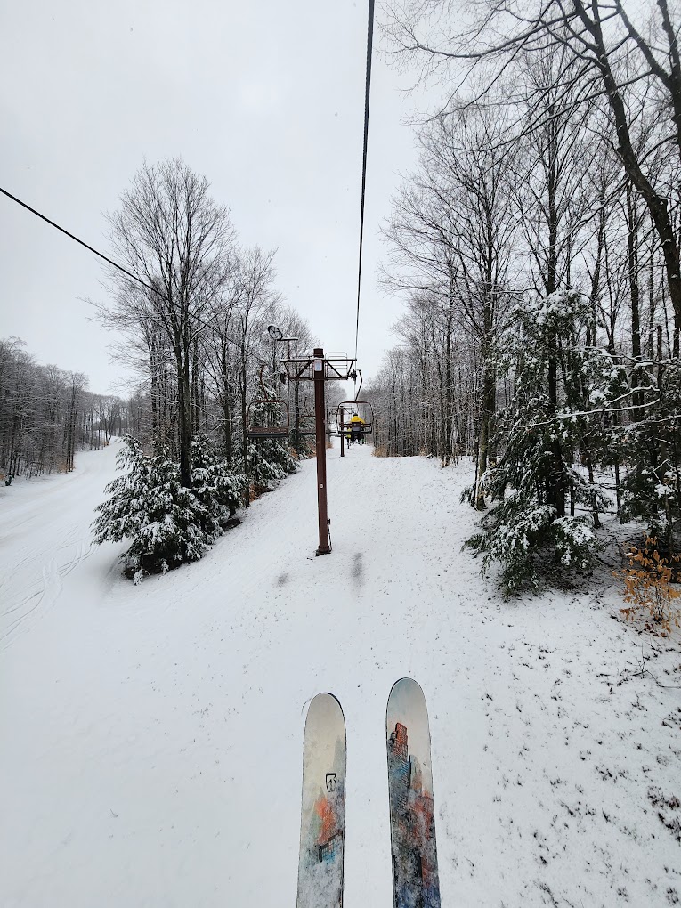 Nubs Nob Ski Area in USA - a snowboard sitting on top of a snow covered hill.