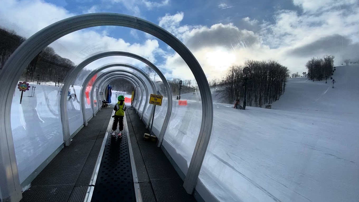 Nubs Nob Ski Area in USA - a person on a snowboard going through a tunnel.