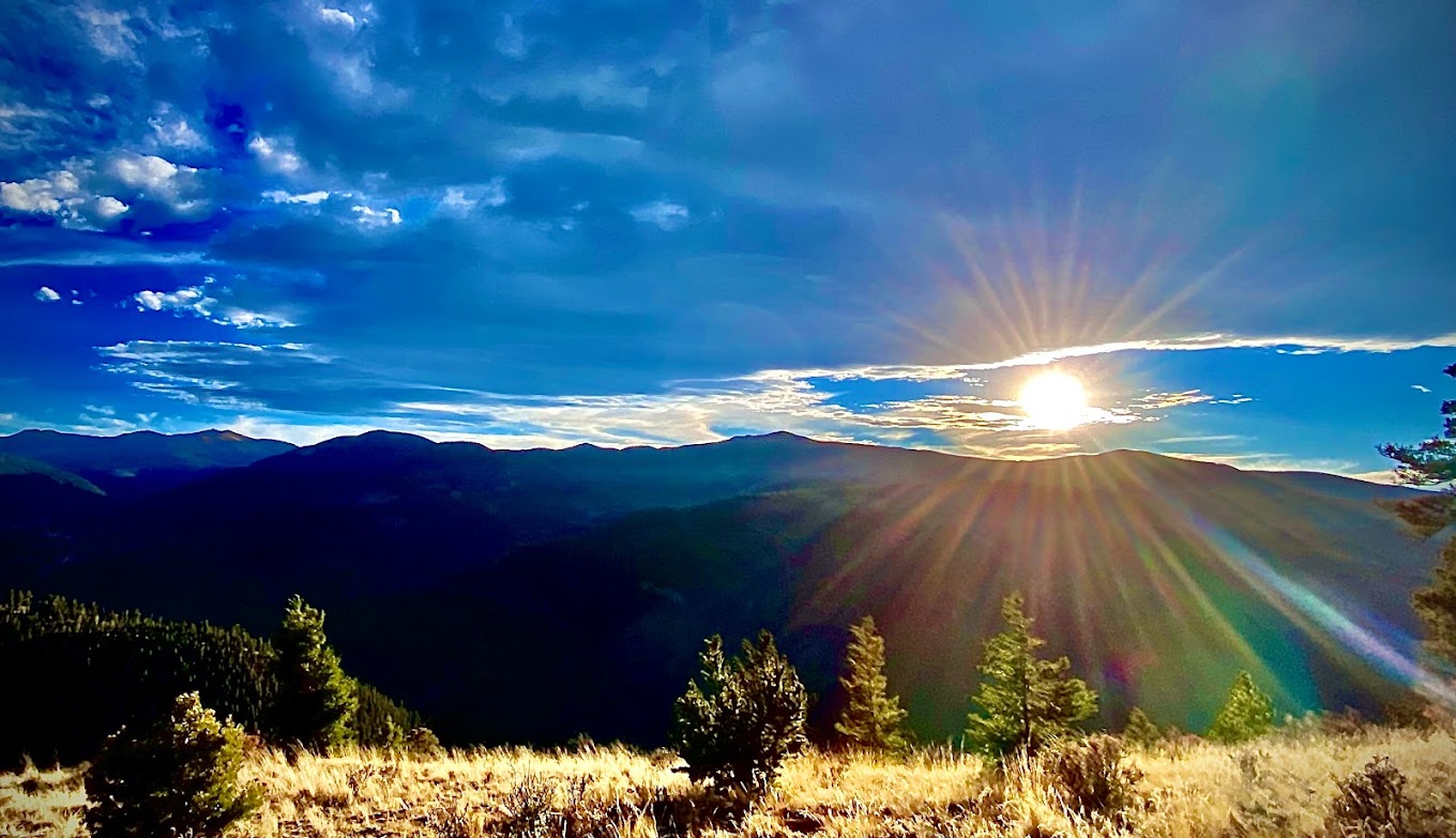 Enchanted Forest Cross Country Ski Area in USA - the sun shines through the clouds over the mountains.