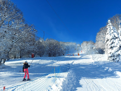 Winter sports scene at Super-Besse in France, highlighting a ski resort with a ski lift and a skier, encapsulating the vibrant energy of a winter sports centre.