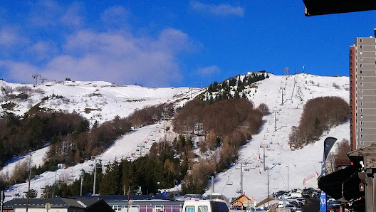 A captivating scene at the Super-Besse ski resort in France with its charming chalet standing amidst the snow-covered slopes. A ski lift adds to the serene winter sports landscape.