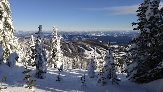 Winter scene at Baldy Mountain Resort in British Columbia, Canada featuring a bustling ski resort, skiers enjoying winter sports amidst stunning winter scenery.