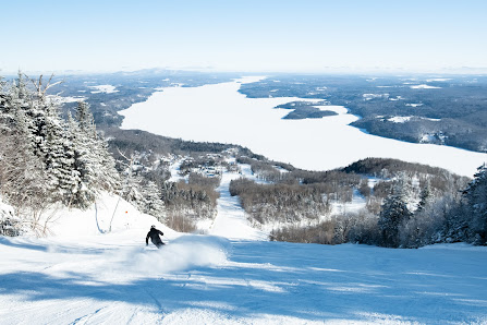 Winter sports scene at Baldy Mountain Resort in Canada, featuring a skier gliding down the slopes amidst a stunning winter backdrop.
