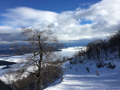 A skier enjoying the wintry beauty at Owl's Head ski resort in Mansonville, Quebec. The surrounding winter landscape enhances the chilly but stunning atmosphere.