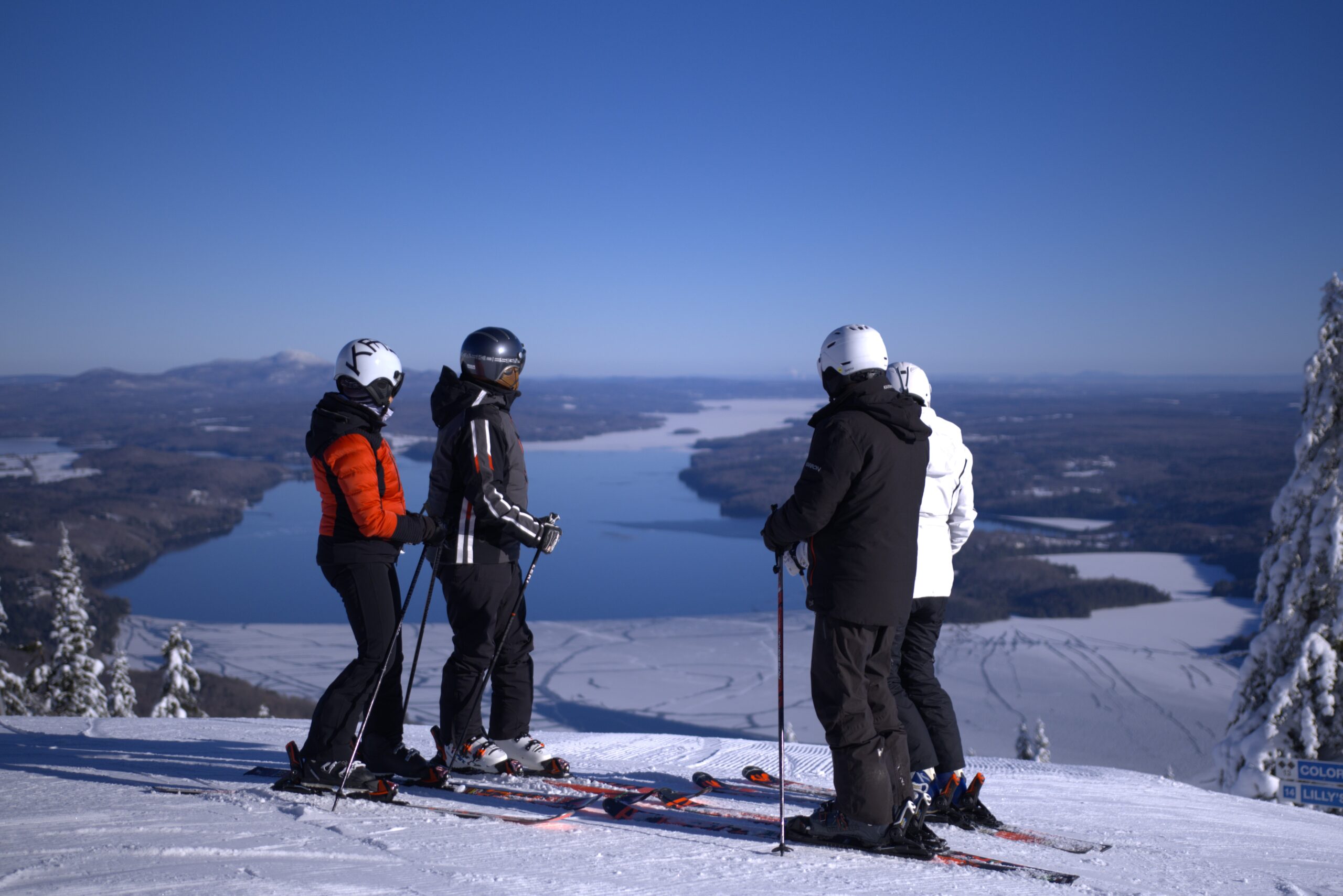 Winter scene at Owl's Head in Quebec, Canada, showcasing a skier gliding down the snowy slopes of the ski resort, with a ski lift visible in a distance.
