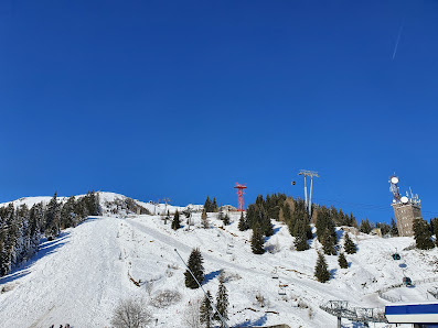 A picturesque winter scene at Owl's Head ski resort in Quebec Canada featuring a ski lift carrying a skier toward the chalet against the backdrop of snowy slopes.