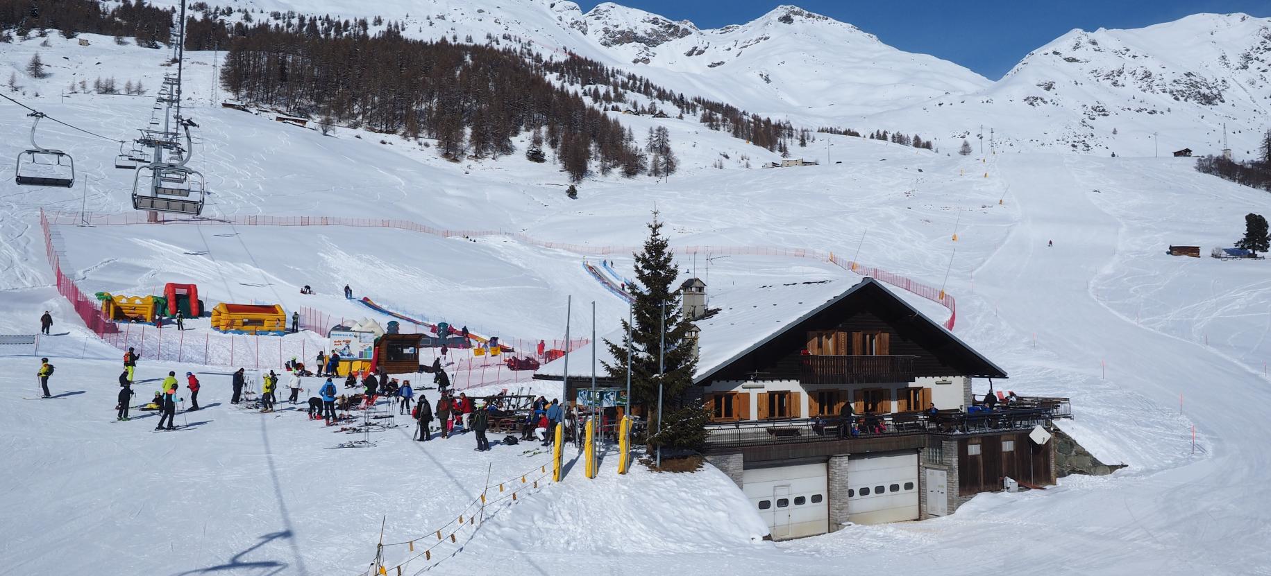Antagnod Pian Pera in Italy - a group of people skiing down a snowy slope.
