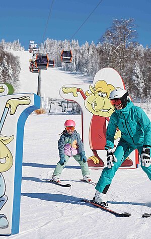 Winter sports scene at Hochficht in Mühlviertel, Upper Austria, featuring a family engaging in skiing at the popular ski resort, with a visible ski lift and individual skiers.