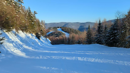 Winter scene at Waterville Valley Resort in New Hampshire, showcasing a vibrant ski sports scene, a charming chalet, and beautiful snowy surroundings.