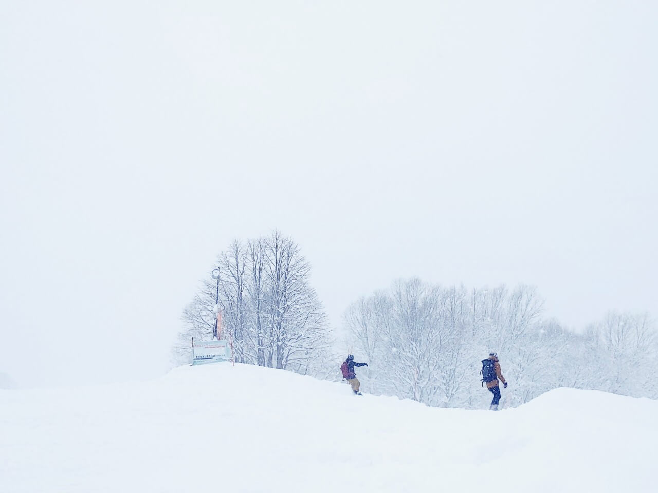 Myoko Akakura Kanko in Japan - two people walking through a snow covered field.