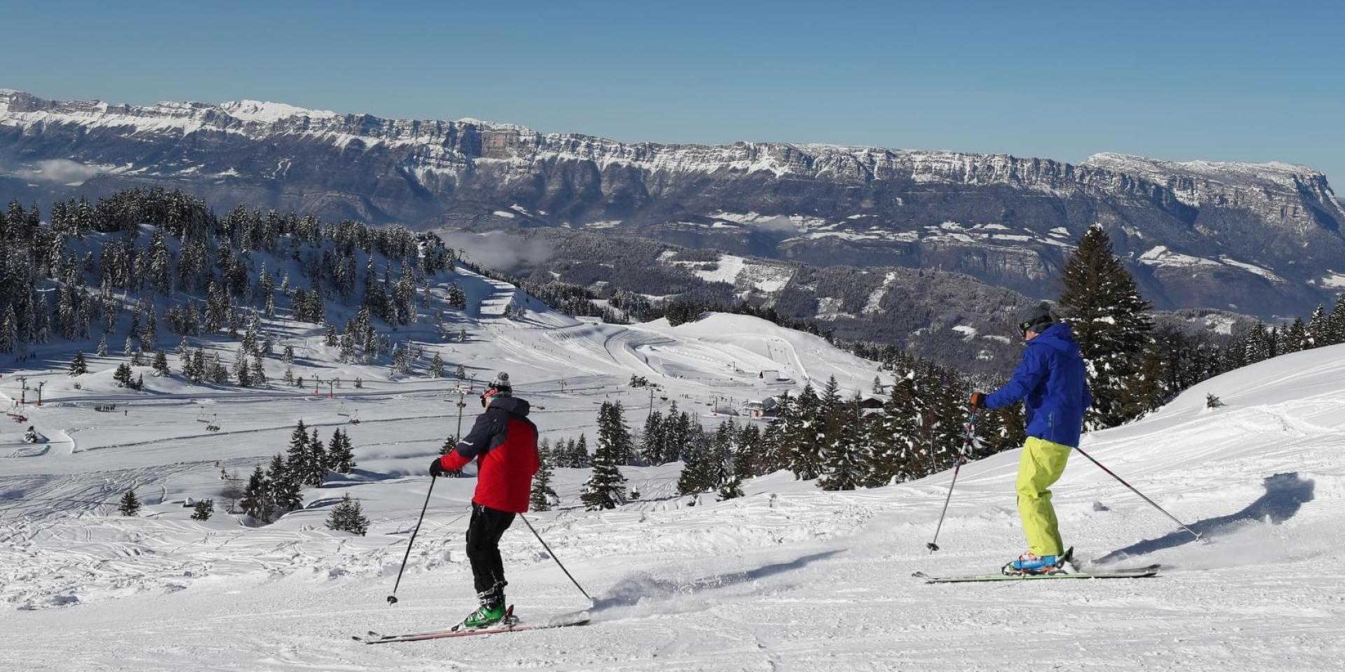 Collet ski resort Allevard in France - two people are skiing down a snowy slope.