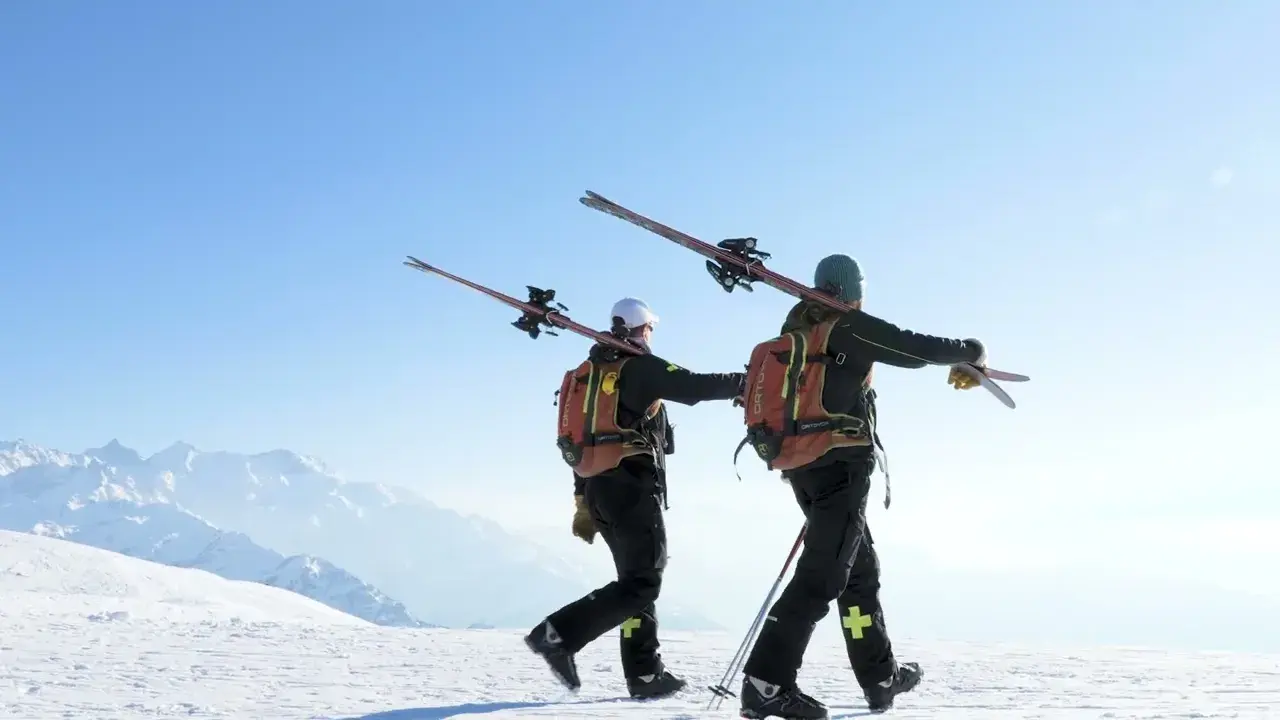 Collet ski resort Allevard in France - two skiers walking up a snowy slope.