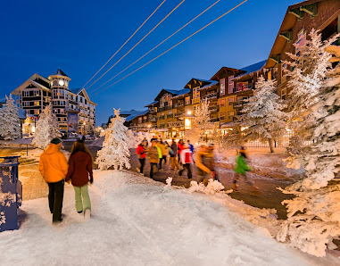Winter at Snowshoe Mountain in West Virginia, featuring a bustling ski resort with on-going winter sports activity. A ski lift facilitates outdoor recreation against a backdrop of stunning winter scenery.