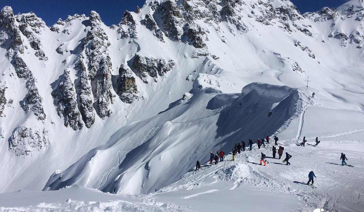 Tetnuldi – Mestia in Georgia - a group of people skiing down the side of a mountain.
