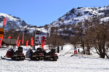 Winter sports enthusiasts enjoying a day at Nevados de Chillan ski resort in Chile, with a chalet peeping out amidst a breathtaking winter landscape.