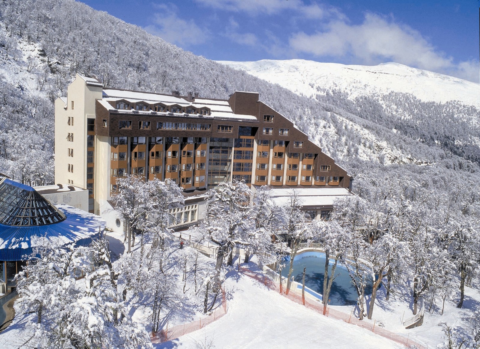 Nevados de Chillan in Chile: a hotel surrounded by snow covered trees.