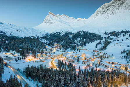 A picturesque ski resort in San Bernardino Mesolcina Calanca Switzerland featuring a charming chalet amidst a stunning winter scenery bustling with winter sports.