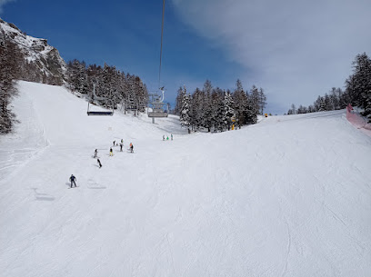 View of a lively ski resort in Braunwald Switzerland featuring a charming chalet bustling winter sports scene and a ski lift serving eager skiers and snowboarders.