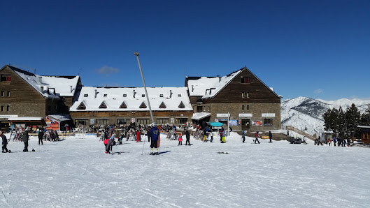 Ski resort at Port Ainé in Catalonia, showing a bustling winter sports scene with a chalet and ski lift in the background.