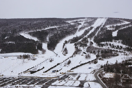 A lively scene at Mizuho Highland ski resort in Japan, showcasing snow-covered slopes, active winter sports enthusiasts, and a prominent ski lift.