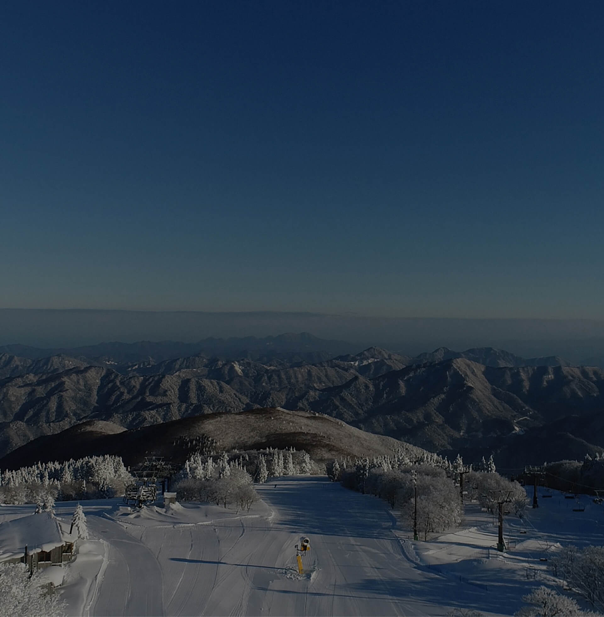 Image of a breathtaking winter wonderland at Mizuho Highland in Japan. Spectators are enjoying vibrant winter sports scenes at this prominent ski resort, set against a backdrop of snowy mountains.