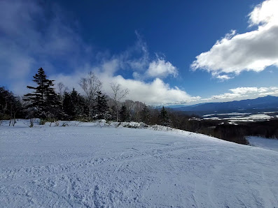 Winter sports enthusiasts enjoying a day at Palcall Tsumagoi in Japan, surrounded by stunning winter scenery of snow-covered mountains and a cozy chalet.