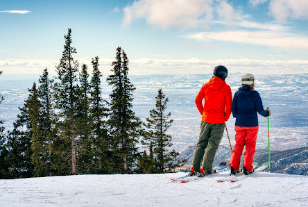 A vibrant winter sports scene at Santa Fé, New Mexico with a family and group of people enjoying skiing against the backdrop of a ski resort. A ski lift adds authenticity to the picturesque skiing destination.