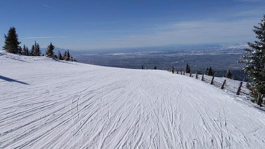 A skier enjoys the snow-covered slopes of a ski resort in Santa Fé New Mexico with a ski lift visible in the background manifesting a captivating winter sports scene.