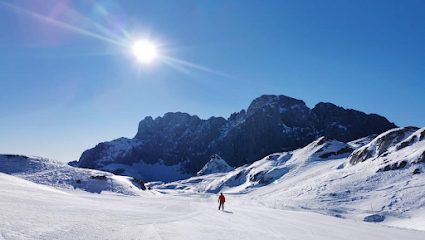 A winter sports scene in Santa Fé New Mexico with a skier sliding down a snowy slope a cozy chalet in the background and a ski resort sprawled amidst a wintry landscape.