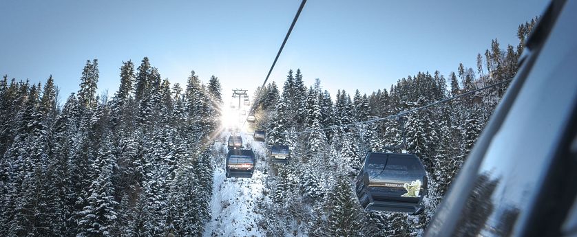 Winter sports enthusiasts enjoying a day at SkiWelt -Brixental in Tyrol, Austria. The stunning winter landscape frames a bustling ski resort, featuring a prominent ski lift.