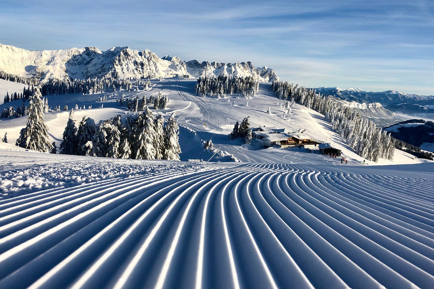 Winter sports scene at SkiWelt-Brixental in Austria, featuring a skier navigating the snow-covered slopes of the ski resort, with a picturesque challet nearby.