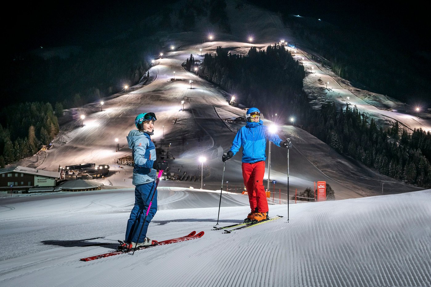 A skier is partaking in winter sports at the SkiWelt -Brixental resort in Söll Tyrol Austria in a lively scene brimming with groups of fellow skiing enthusiasts.