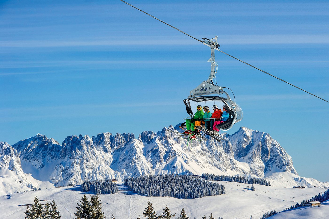 A ski lift moving through a serene winter landscape at SkiWelt-Brixental in Tyrol, Austria, with skiers enjoying winter sports in the snowy surrounds.