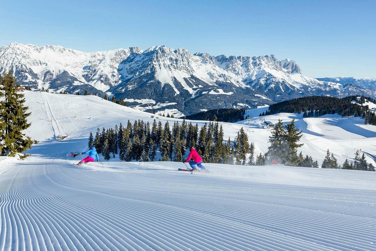 SkiWelt -Brixental in Austria - a person skiing down a snowy slope in the mountains.